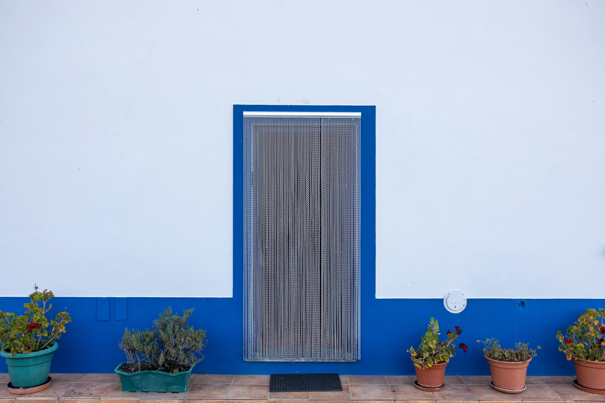 Porta de entrada com cortina de missangas e vasos